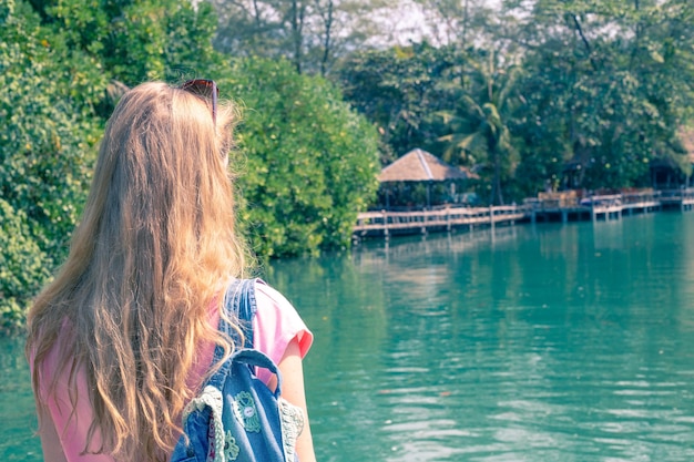 Chica con mochila en el río.