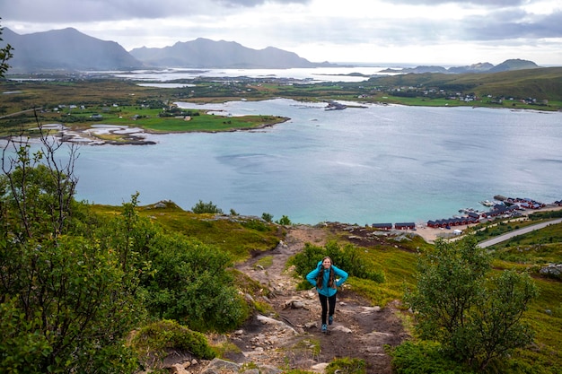 chica con mochila senderismo Offersykammen trail head admirando el panorama de las islas lofoten, Noruega