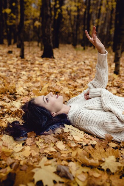 Chica de moda al aire libre. Mujer de otoño divirtiéndose en el parque y sonriendo.
