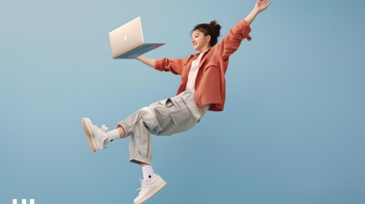 Una chica de moda está flotando en el aire sosteniendo una computadora portátil