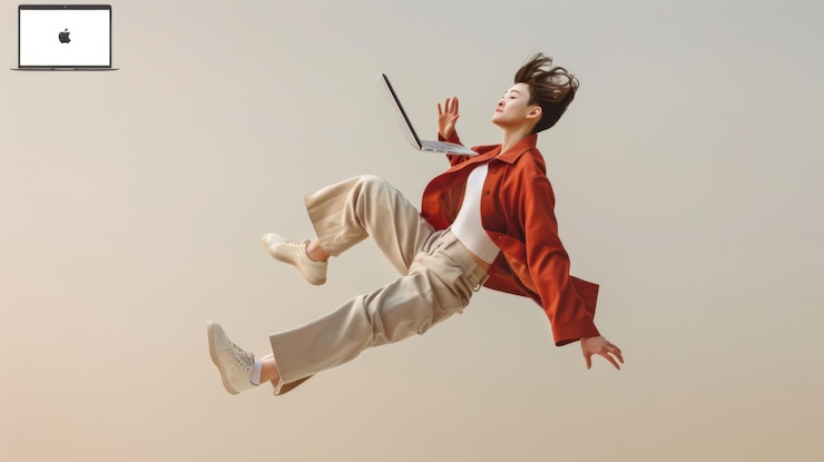 Una chica de moda está flotando en el aire sosteniendo una computadora portátil