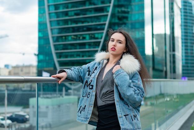 Una chica de moda con un peinado ondulado y labios rojos posa en la calle