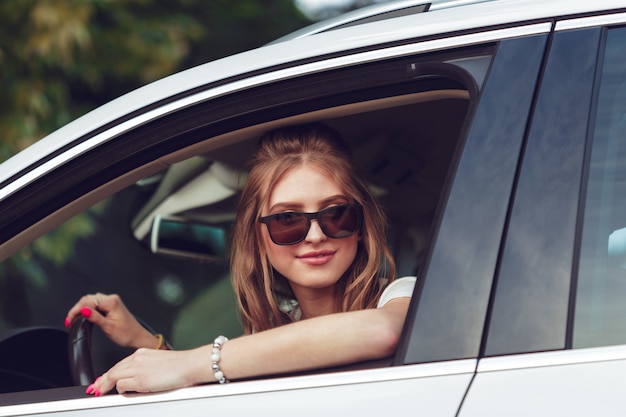 Chica de moda que viaja en coche