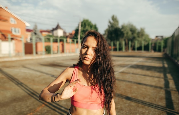 Chica de moda en ropa deportiva se encuentra en el antiguo patio de recreo deportivo