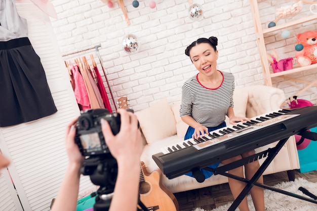 Chica de moda tocar el teclado y canta