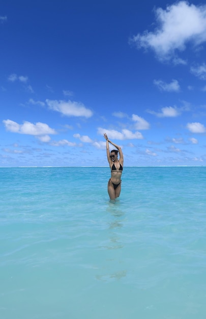 chica modelo en bikini negro nada en el océano