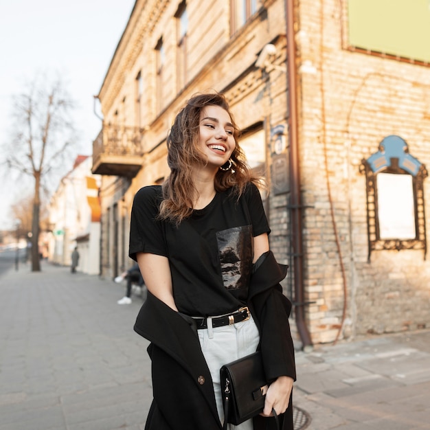 Chica modelo feliz en traje de moda camina en la calle