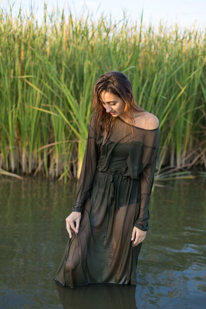 Chica mojada en el agua con cañas, retrato emocional de una chica en el agua