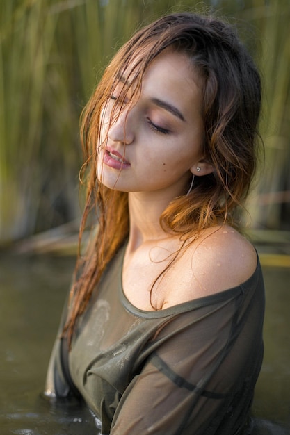 Chica mojada en el agua con cañas retrato emocional de una niña en el agua