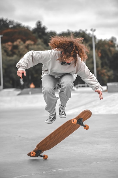 Chica en el momento de saltar por encima de la patineta