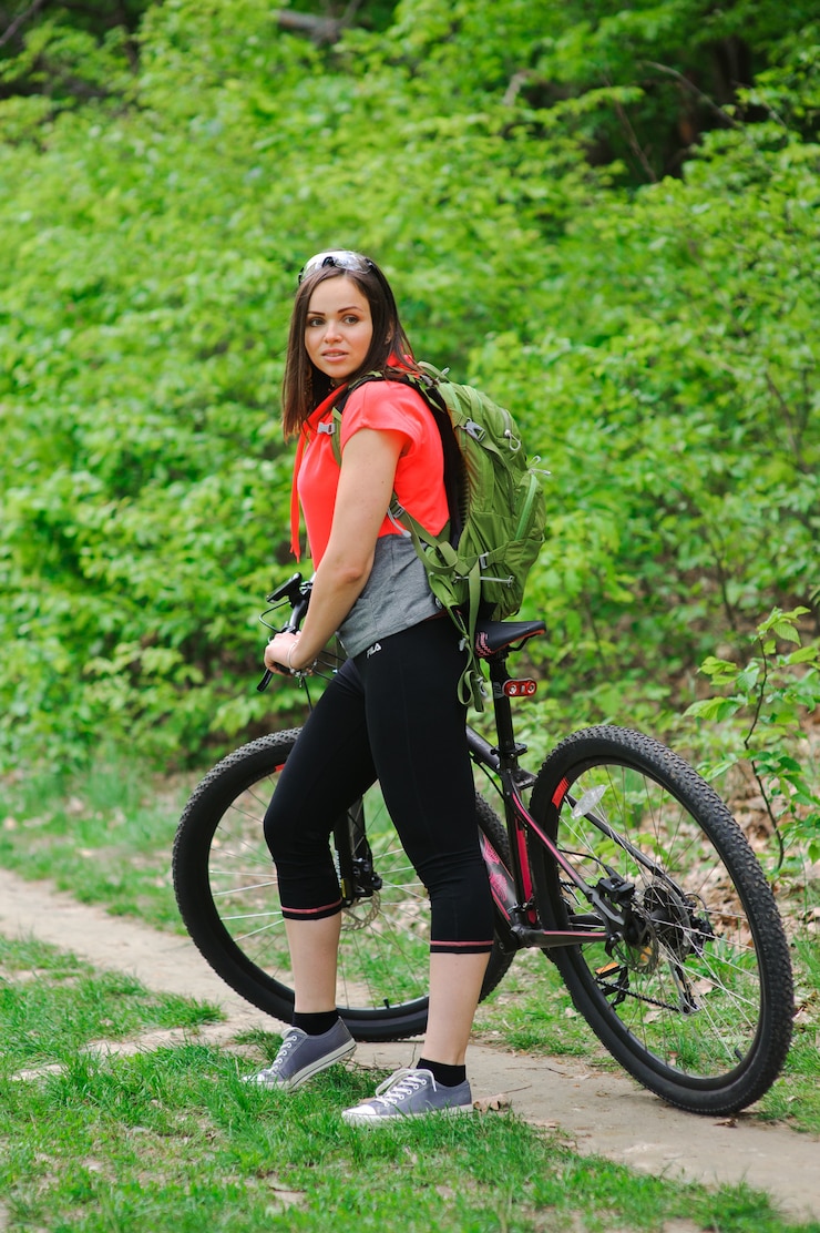 Foto chica montando una bicicleta en el bosque