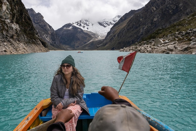 Chica montando en un bote de remos en una laguna entre montañas