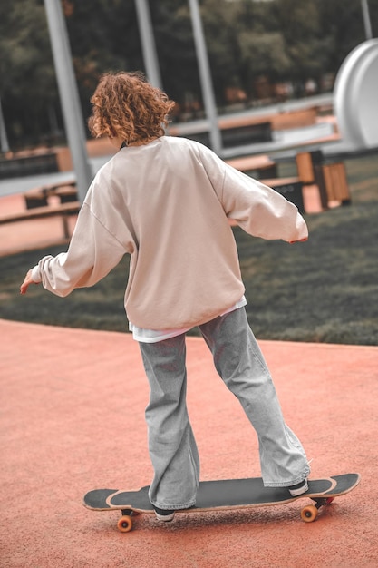 Chica montando patineta de espaldas a la cámara