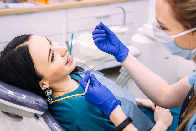 Chica morena atractiva en la consulta del dentista