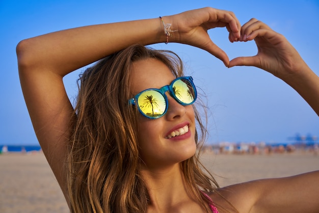 Chica morena gafas de sol con palmera