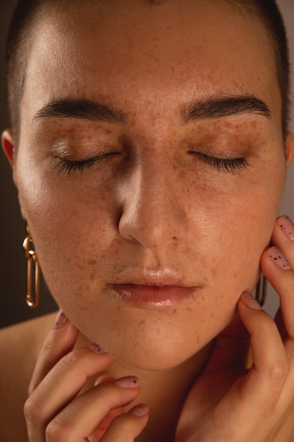 Foto una chica morena con pelo corto y pecas con los ojos cerrados auténtico retrato en primer plano