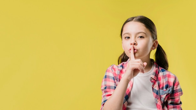 Foto chica mostrando signo de silencio en estudio