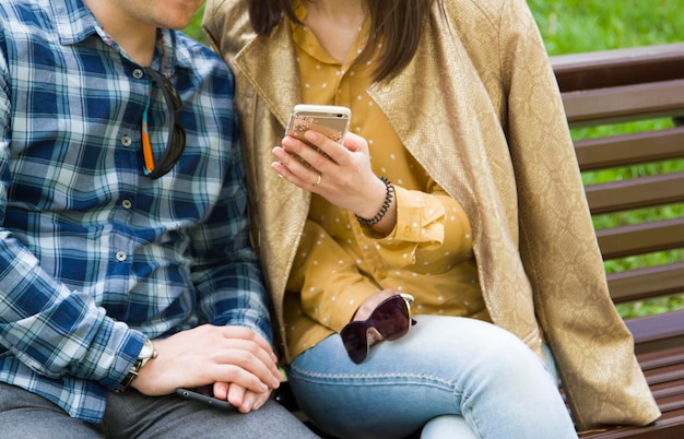 Una chica le muestra algo a un chico en un teléfono.