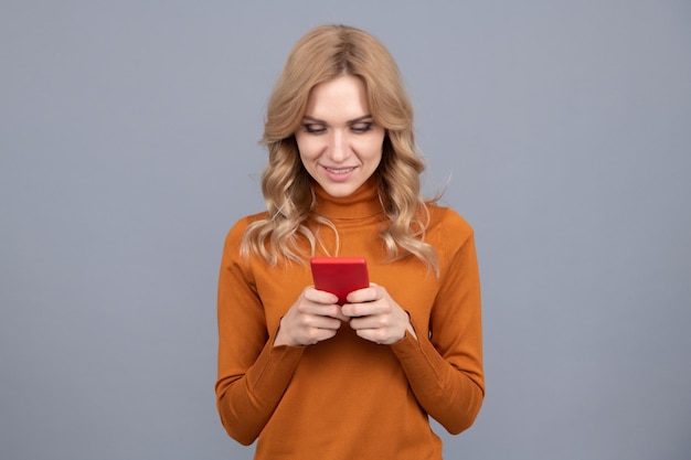 Chica mujer moderna revisando correos electrónicos o enviando mensajes de texto en el teléfono inteligente