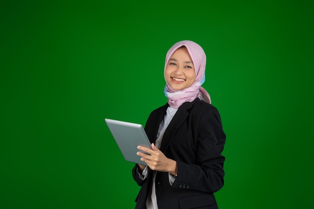 Chica musulmana en hijab usando una tableta digital con copyspace