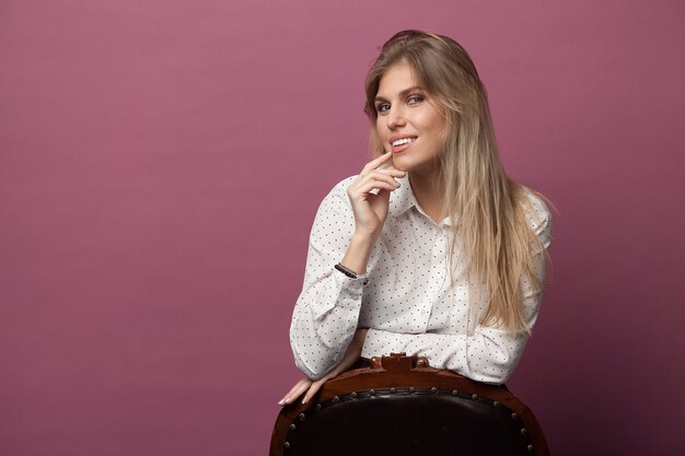 Chica muy elegante con cabello rubio posando en rosa. Retrato de estilo de moda de moda de joven mujer sonriente feliz