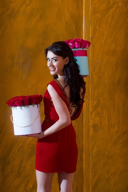 Chica muy feliz sonriendo con rosas en cajas