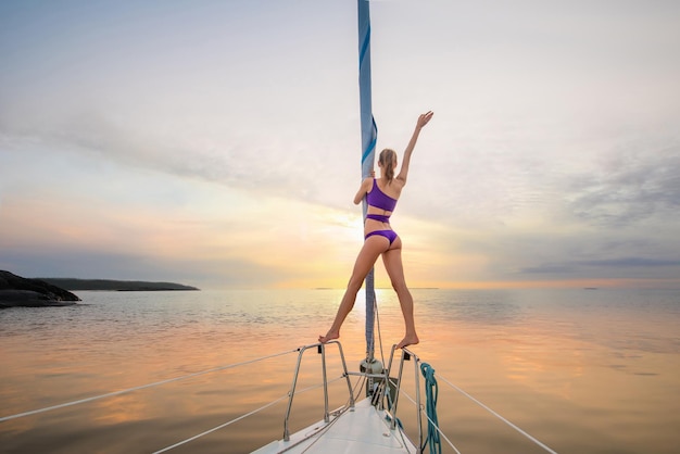 Chica navegando en el yate en una reunión, la chica del sol agita su mano desde el paseo romántico del yate en t