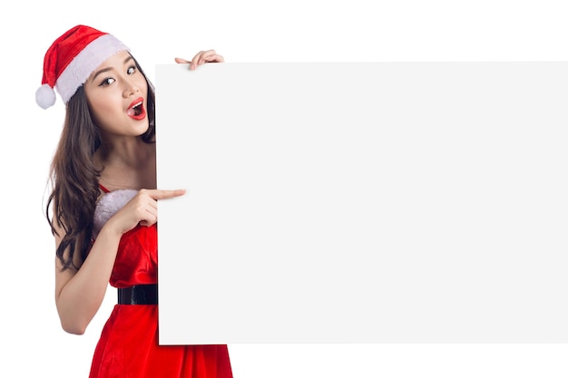 Chica de Navidad asiática con ropa de Santa Claus con cartel en blanco aislado sobre fondo blanco.