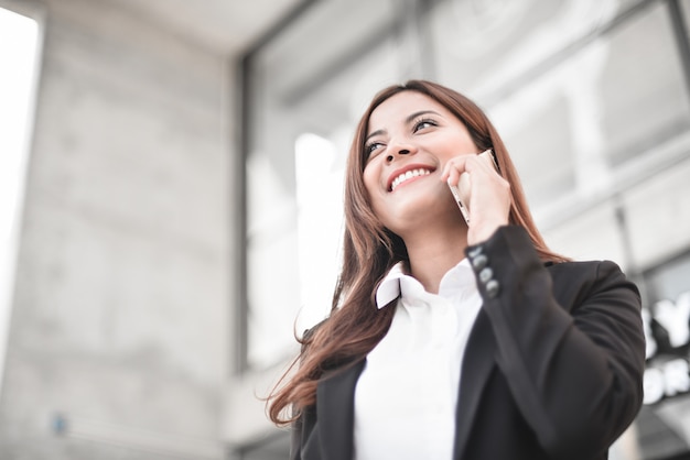 Chica de negocios asiáticos con teléfono inteligente