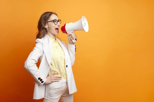 Chica de negocios con gafas y traje anuncia información al gerente de megáfono al estilo de la oficina