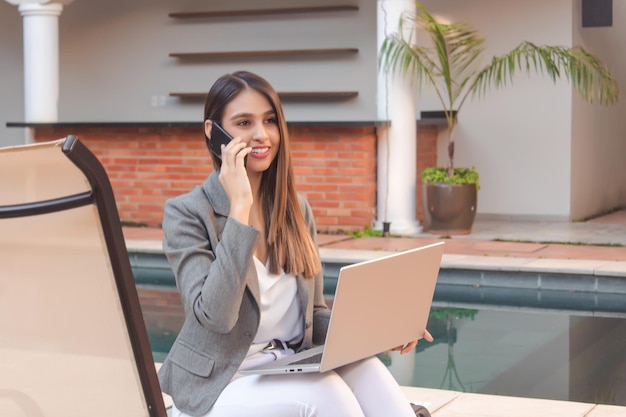 Chica de negocios hablando por teléfono en el patio de un hotel