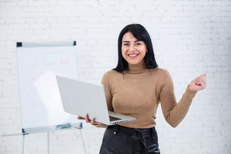 Chica de negocios, maestra, formadora enseña y habla sobre un nuevo proyecto de pie cerca de la pizarra