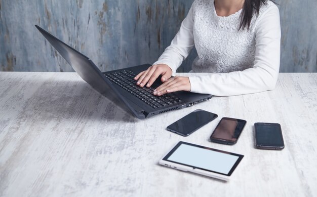 Chica de negocios usando la computadora portátil en la oficina.