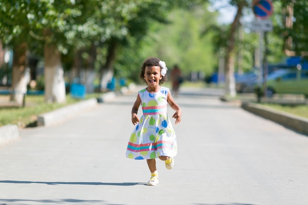 Chica negra corre sobre el asfalto.