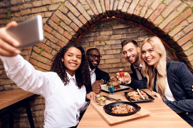 Una chica negra hace selfie con amigos.