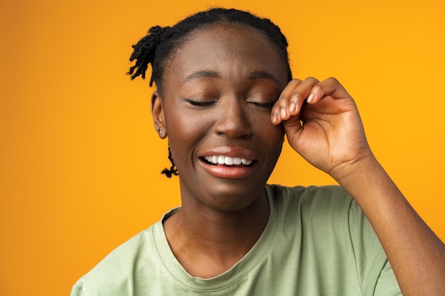 Chica negra molesta llorando con problemas de vida de fondo amarillo