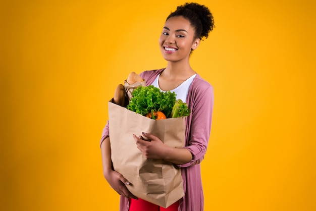 Chica negra con un paquete de productos.