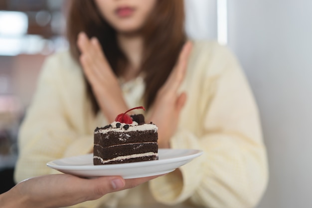 Chica niega comer dulce o tarta durante la dieta.