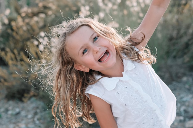 Chica de niño emocional emocionado feliz sobre fondo de naturaleza de verano cara feliz