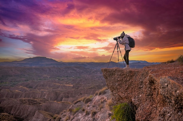 Chica observando el paisaje badland al atardecer en el desierto del Geoparque de Granada