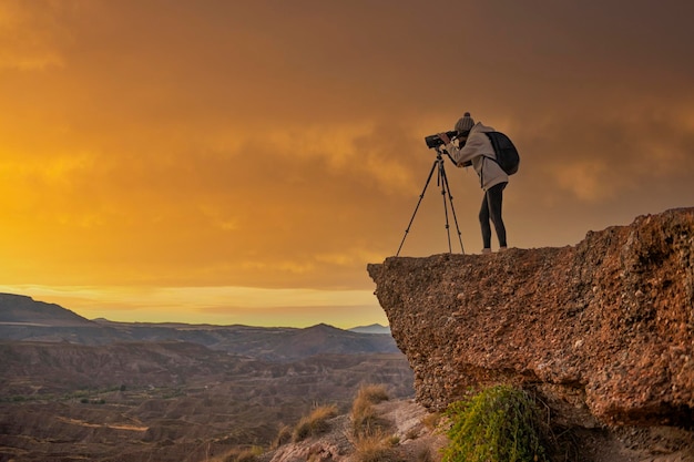 Chica observando el paisaje badland al atardecer en el desierto del Geoparque de Granada