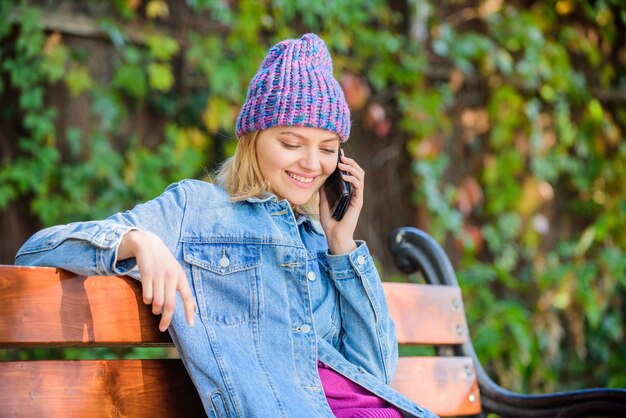 Chica ocupada con el fondo de la naturaleza verde del teléfono inteligente Mujer que tiene una conversación móvil Amigo de la llamada del teléfono inteligente de la niña Manténgase en contacto con el teléfono inteligente moderno Concepto de llamada móvil Te estoy esperando en el parque