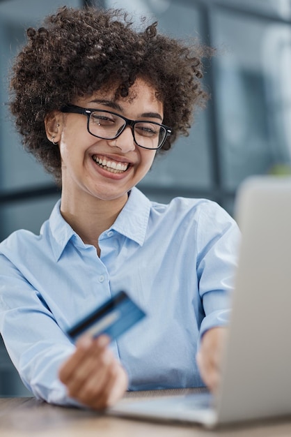 Foto una chica en una oficina moderna paga las compras en internet usando una tarjeta de crédito