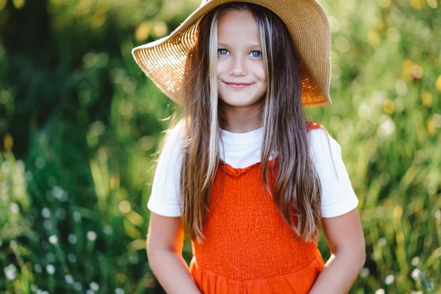 Una chica con ojos azules en un sombrero en la calle mirando a la cámara y sonriendo