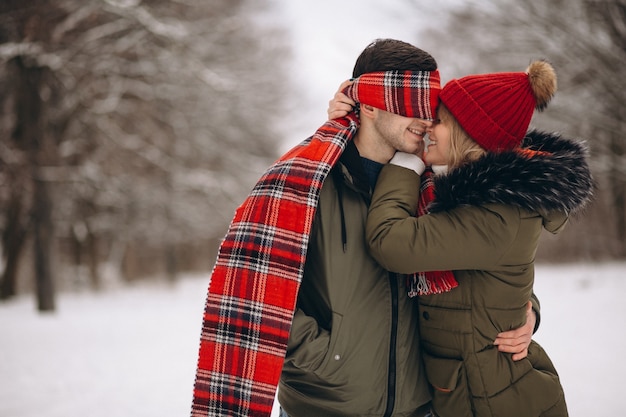 Chica con los ojos vendados hombre en el día de San Valentín en un parque de invierno