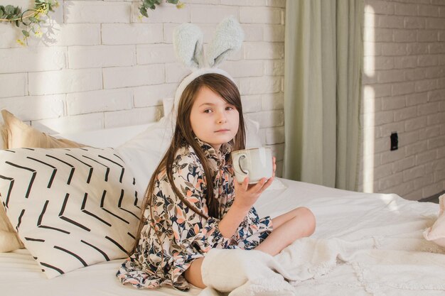 Chica con orejas de conejo bebiendo té