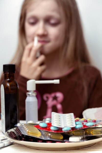 Chica con un pañuelo y pastillas en primer plano