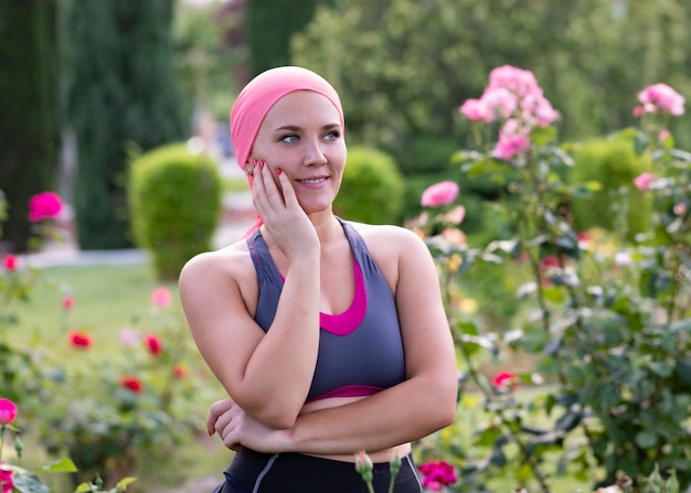 Foto chica con un pañuelo rosa en el parque