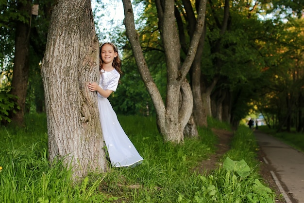 Chica en el parque de cuento de hadas con árbol en primavera