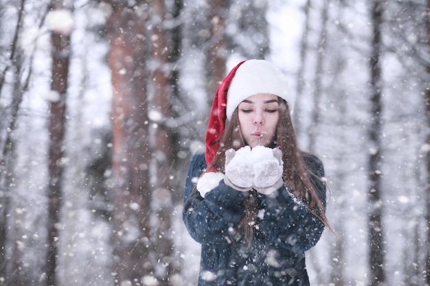 Chica en un parque de invierno por la tarde en nevadas